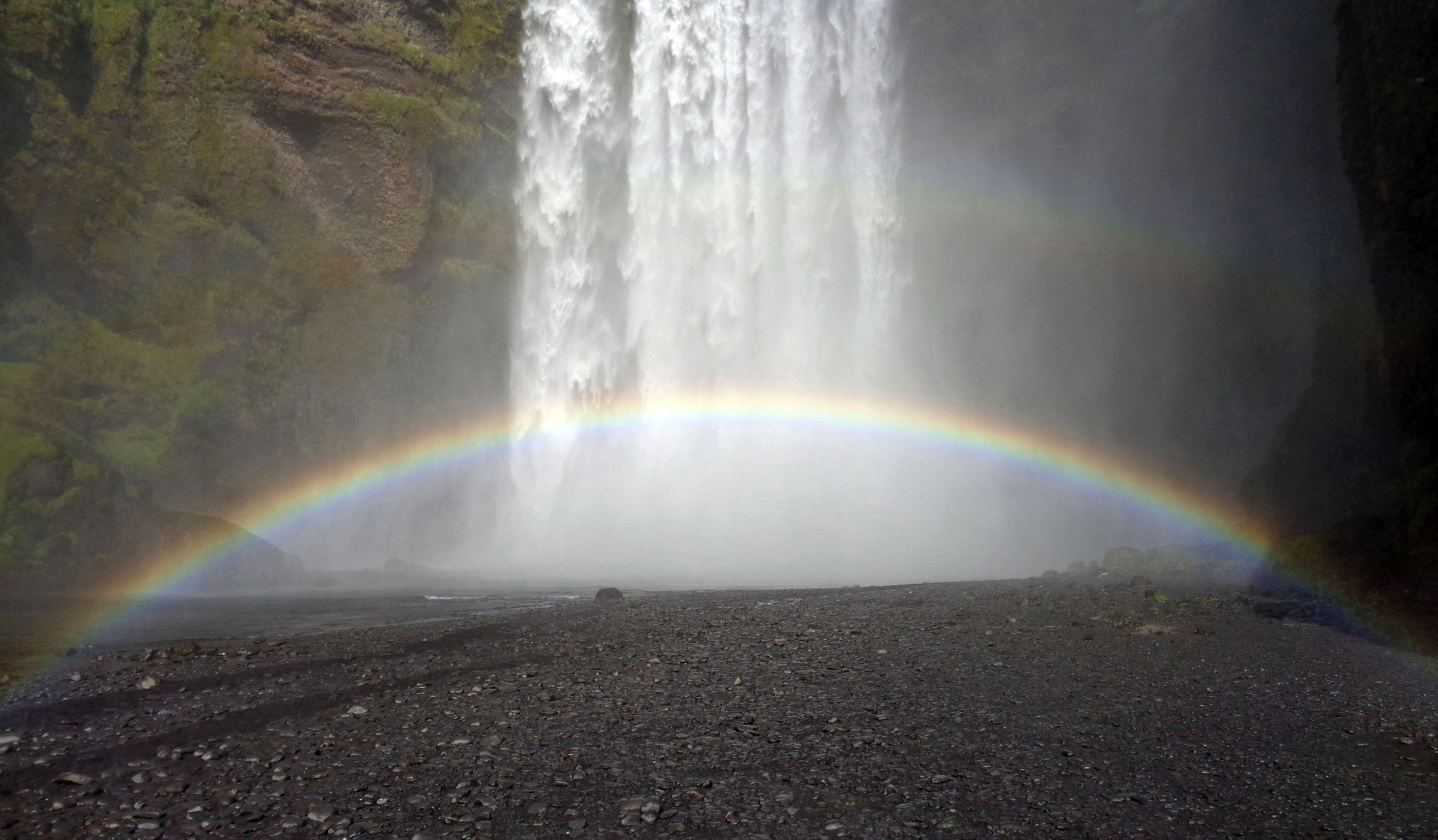 Double rainbow in front of waterfall.